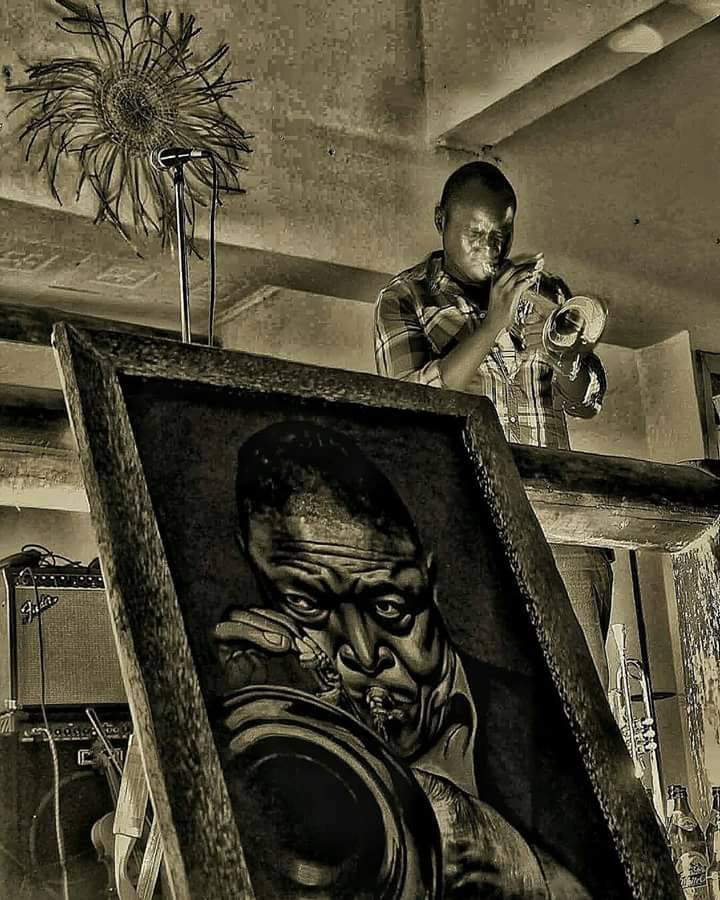 Mackinlay Mutsembi Playing his music next to a Hugh Masekela painting